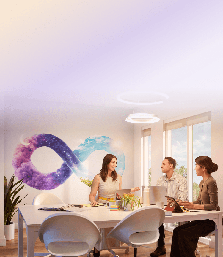 Colleagues in an office meeting with an infinity symbol mural on the wall