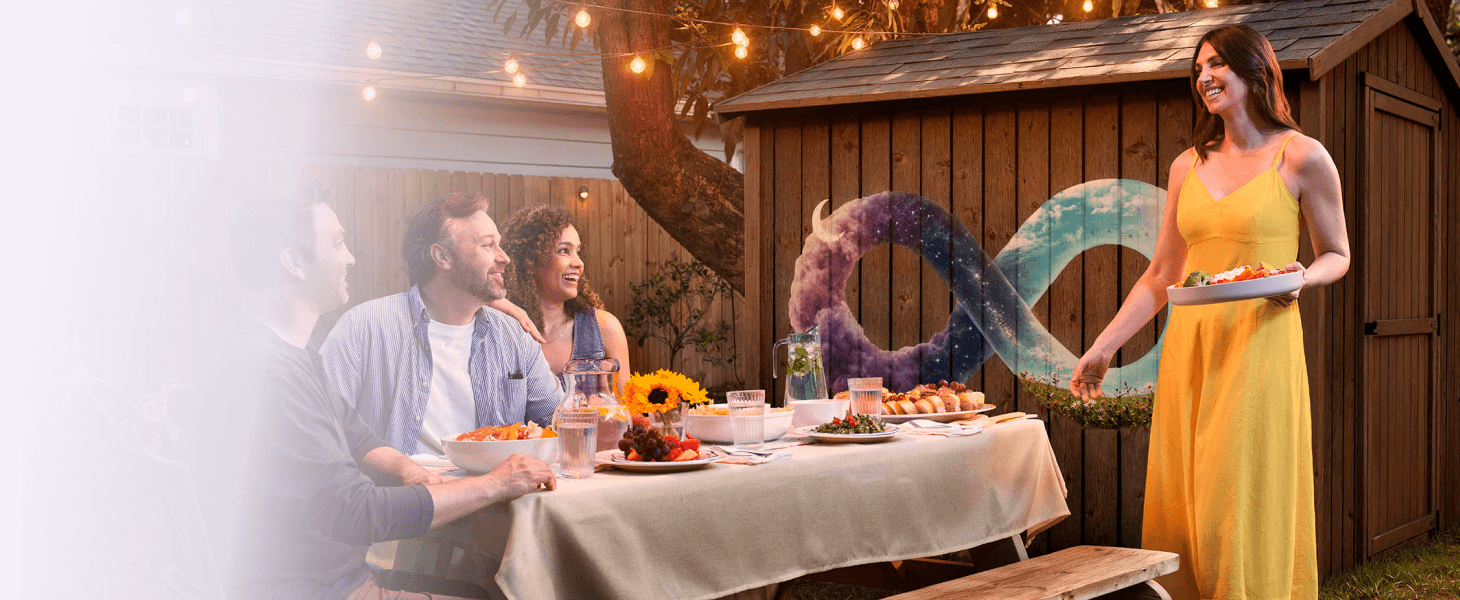 People enjoying an outdoor dinner party with an infinity symbol mural in the background
