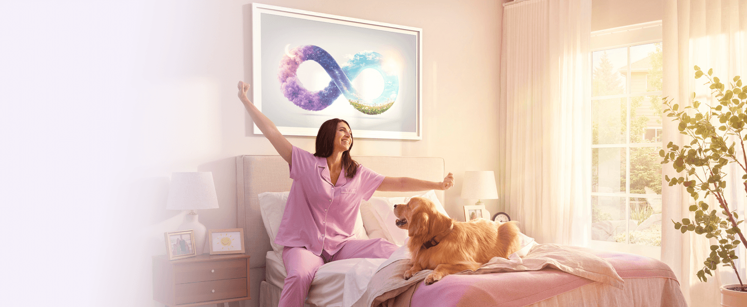 A woman stretching in bed with her dog, with an infinity symbol wall art above